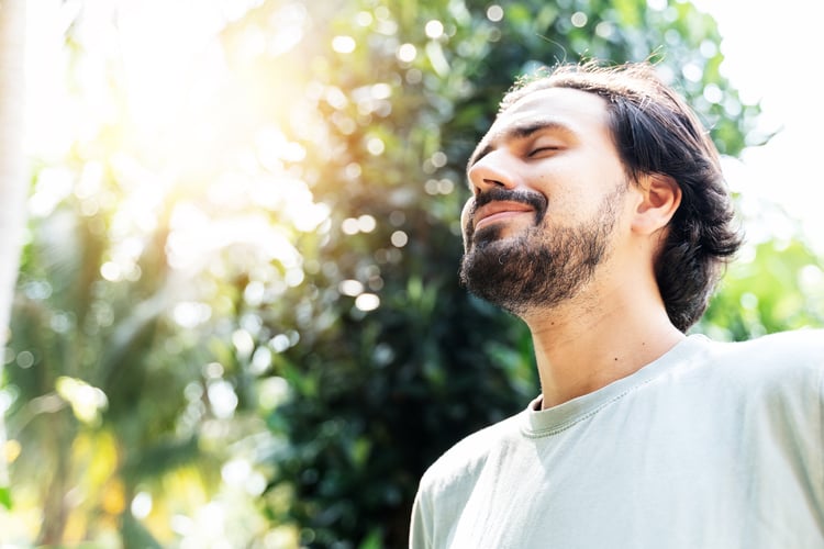 Mid shot of man smiling in the sun with green and yellow blue